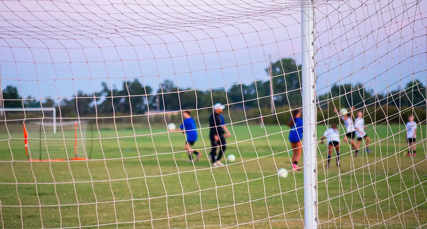 Kids playing soccer with coach